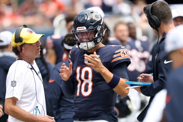 Bears quarterback Caleb Williams talks with coaches on the sideline in the first quarter of a preseason game against the Bengals at Soldier Field on Aug. 17, 2024, in Chicago. (John J. Kim/Chicago Tribune)