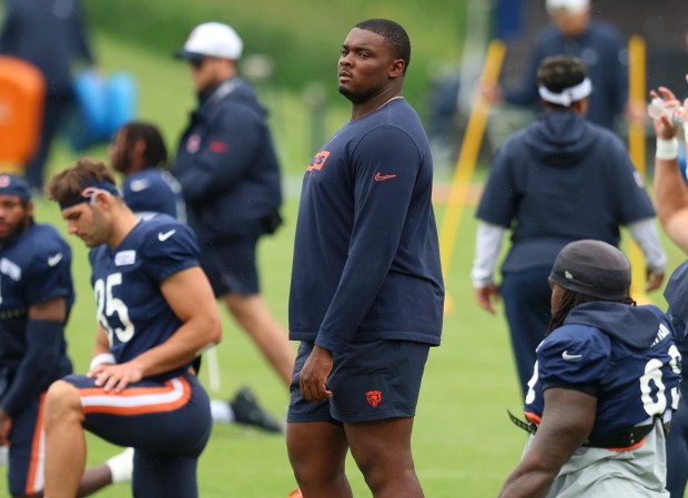 Injured Bears offensive tackle Kiran Amegadjie walks among players during practice at Halas Hall on Aug. 15, 2024. (Stacey Wescott/Chicago Tribune)