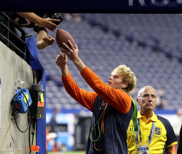 Chicago Bears punter Tory Taylor (19) signs a football after warm-ups before the start of a game between the Chicago Bears and the Indianapolis Colts at Lucas Oil Stadium on Sept. 22, 2024, in Indianapolis. (Stacey Wescott/Chicago Tribune)