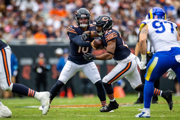 Chicago Bears quarterback Caleb Williams (18) passes the ball to Chicago Bears running back Roschon Johnson (23) during the second half of the game against the Los Angeles Rams. (Tess Crowley/Chicago Tribune)