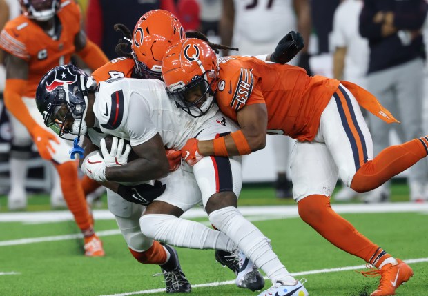 Texans wide receiver Stefon Diggs is tackled by Bears linebacker Tremaine Edmunds (49) and cornerback Kyler Gordon (6) in the third quarter on Sept. 15, 2024, in Houston. (John J. Kim/Chicago Tribune)