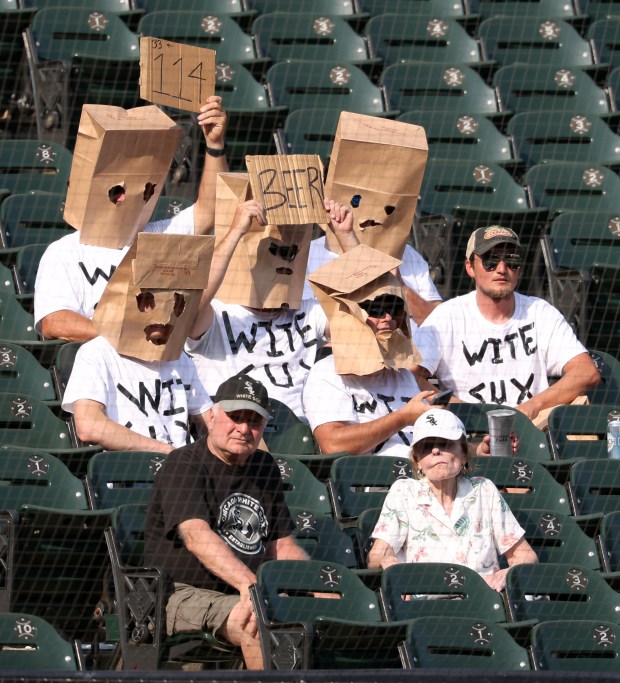 A group of fans wear matching T-shirts and paper bags over their heads in the ninth inning between the White Sox the Guardians at Guaranteed Rate Field on Sept. 11, 2024, in Chicago. (John J. Kim/Chicago Tribune)