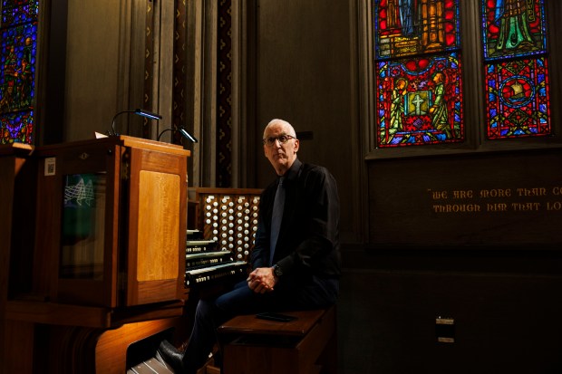 Organist Phillip Kloeckner sits in front of the organ at the First United Methodist Church's Chicago Temple Building on Tuesday, Sept. 17, 2024, in Chicago. The organ was installed the same year the Temple opened in 1924 and less than 50 percent of the instrument is fully functional due to age, deterioration, electrical malfunction, and water damage from leaks in the floors above the church. (Armando L. Sanchez/Chicago Tribune)