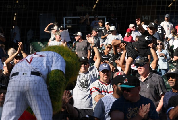 A young fan is hoisted in hopes of getting White Sox mascot Southpaw's attention after a 7-0 win over the Angels in the final home game of the season at Guaranteed Rate Field. (John J. Kim/Chicago Tribune)