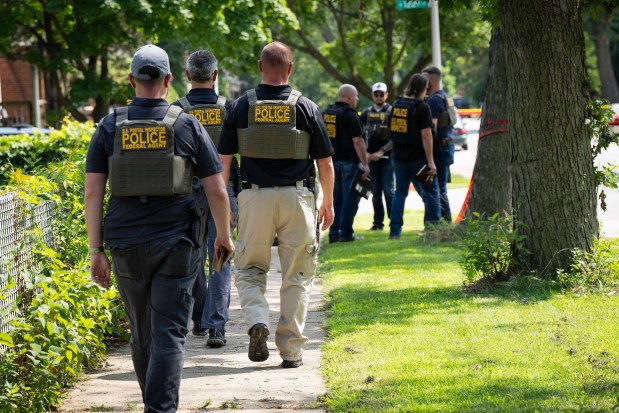 Chicago Police and U.S. Postal Inspector Police investigate the scene on the 12100 block of South Harvard where a U.S. mail carrier was shot and killed in the West Pullman neighborhood, Friday, July 19, 2024. (E. Jason Wambsgans/Chicago Tribune)