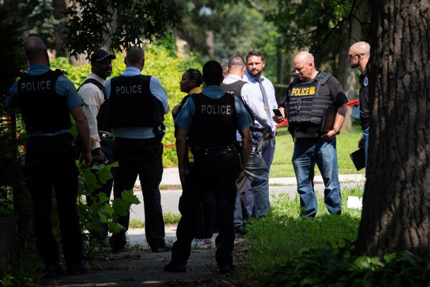 Chicago Police and U.S. Postal Inspector Police investigate the scene on the 12100 block of South Harvard where a U.S. mail carrier was shot and killed in the West Pullman neighborhood, Friday, July 19, 2024. (E. Jason Wambsgans/Chicago Tribune)