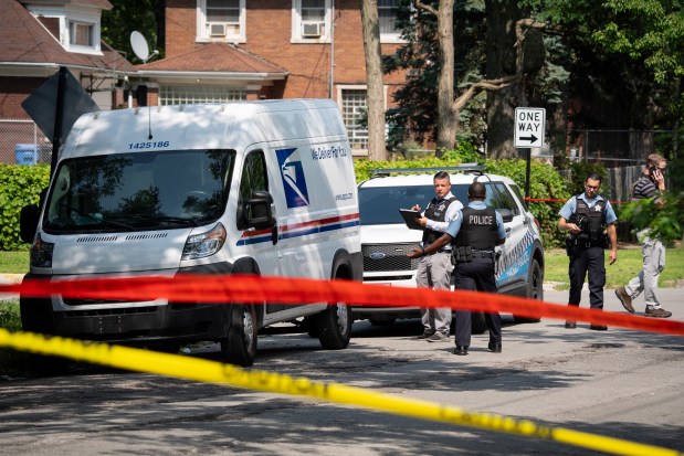 Chicago Police and U.S. Postal Inspector Police investigate the scene on the 12100 block of South Harvard where a U.S. mail carrier was shot and killed in the West Pullman neighborhood, Friday, July 19, 2024. (E. Jason Wambsgans/Chicago Tribune)