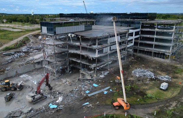 Demolition crews raze buildings at the former Sears campus headquarters in Hoffman Estates on Aug. 28, 2024. Over a two-year period, demolition crews will take down 2.4 million square feet of buildings and another million of parking garage space. The campus was acquired by Compass Datacenters. (Stacey Wescott/Chicago Tribune)