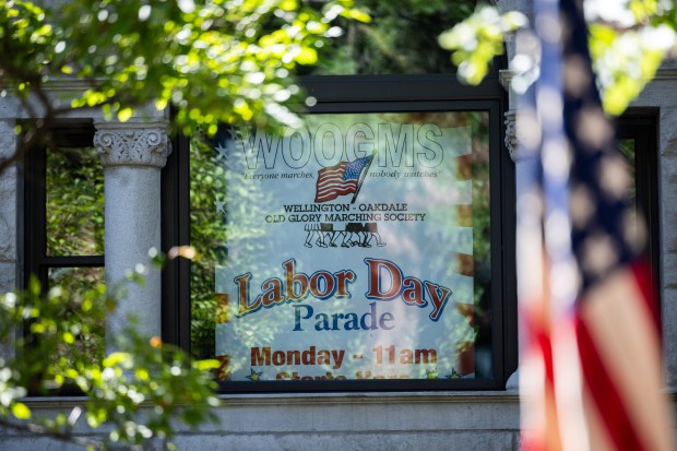 A sign in a window announces the WOOGMS parade in the Lakeview neighborhood of Chicago on Sept. 2, 2024. (Tess Crowley/Chicago Tribune)