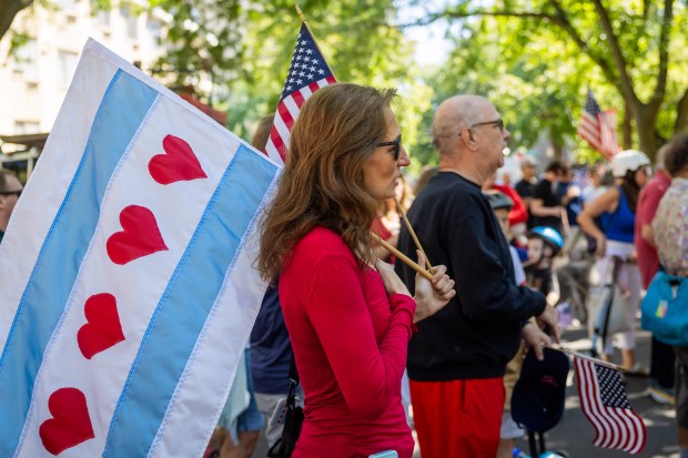 Parade participants recite the Pledge of Allegiance before the start of the WOOGMS parade in the Lakeview neighborhood of Chicago on Sept. 2, 2024. (Tess Crowley/Chicago Tribune)