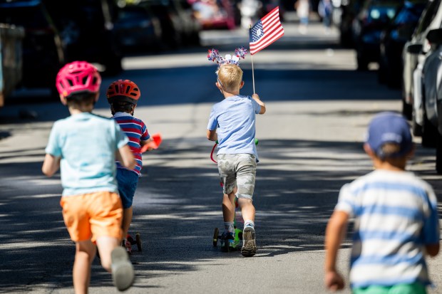 Parade participants ride scooters during the WOOGMS parade in the Lakeview neighborhood of Chicago on Sept. 2, 2024. (Tess Crowley/Chicago Tribune)