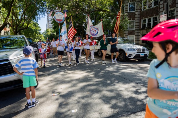 Children watch as parade participants walk in the WOOGMS parade in the Lakeview neighborhood of Chicago on Sept. 2, 2024. (Tess Crowley/Chicago Tribune)