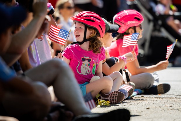 Children watch as members of the Jesse White Tumbling Team perform during the WOOGMS parade in the Lakeview neighborhood of Chicago on Sept. 2, 2024. (Tess Crowley/Chicago Tribune)