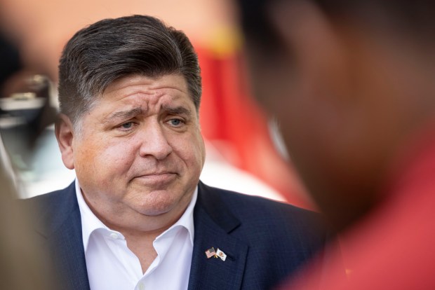 Gov. JB Pritzker speaks with reporters after an announcement about J.P. MorganChase committing $10 million in low-interest loans to advance affordable housing development on the South and West sides on Sept. 10, 2024, in the Austin neighborhood. (Brian Cassella/Chicago Tribune)