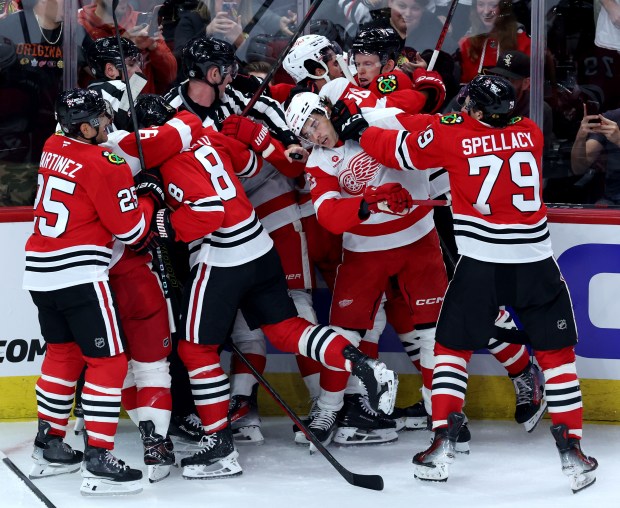 The Blackhawks, including AJ Spellacy (79), tussle with the Red Wings in the first period of a preseason game on Sept. 25, 2024, at the United Center. (Chris Sweda/Chicago Tribune)