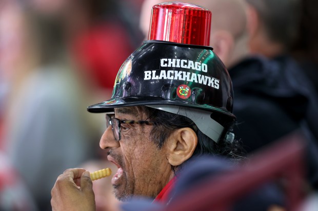 A Blackhawks fan snacks on fries in the second period of a preseason game against the Red Wings at the United on Sept. 25, 2024. (Chris Sweda/Chicago Tribune)