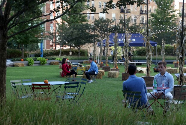 Workers sit in The Green outside the new BMO offices along Canal Street on Sept. 25, 2024, in Chicago. (Stacey Wescott/Chicago Tribune)