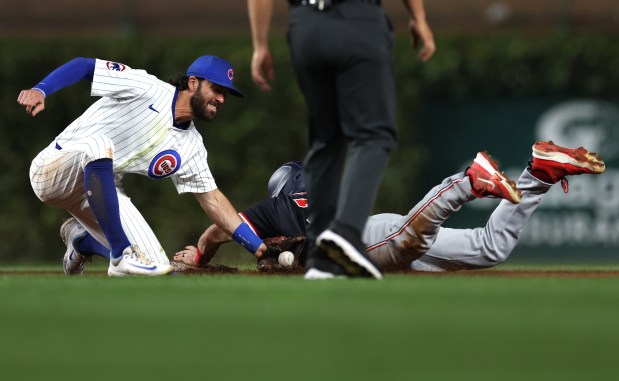 Cubs shortstop Dansby Swanson tags out Nationals center fielder Jacob Young at second base on a steal attempt in the second inning on Sept. 19, 2024, at Wrigley Field. (Chris Sweda/Chicago Tribune)