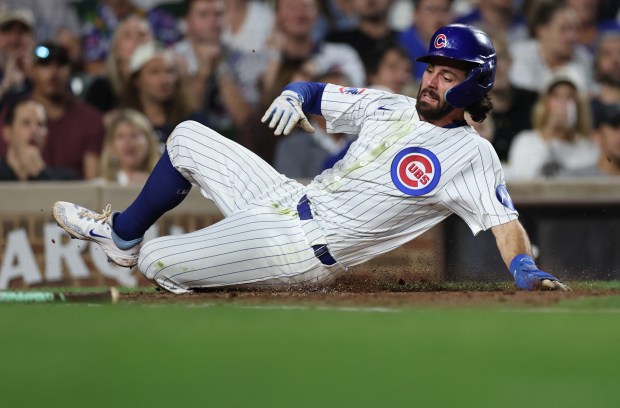 Chicago Cubs shortstop Dansby Swanson slides in safely at home plate while scoring on a sacrifice fly by teammate Isaac Paredes in the fifth inning of a game against the Washington Nationals at Wrigley Field in Chicago on Sept. 19, 2024. (Chris Sweda/Chicago Tribune)