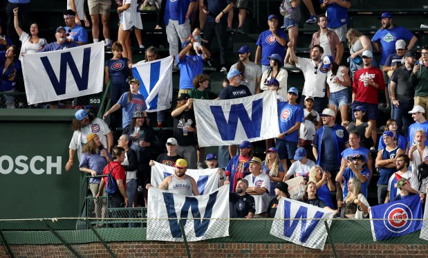 Chicago Cubs fans in the left field bleachers celebrate with W flags after a Cubs victory over the Washington Nationals at Wrigley Field in Chicago on Sept. 19, 2024. (Chris Sweda/Chicago Tribune)