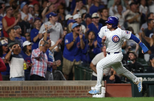 Chicago Cubs outfielder Ian Happ (8) sprints home to score on a single by teammate Cody Bellinger in the seventh inning of a game against the Washington Nationals at Wrigley Field in Chicago on Sept. 19, 2024. (Chris Sweda/Chicago Tribune)