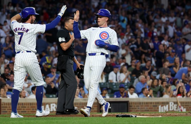 Chicago Cubs shortstop Dansby Swanson (7) and center fielder Pete Crow-Armstrong (right) celebrate after both scored on a single by teammate Ian Happ in the second inning of a game against the Pittsburgh Pirates at Wrigley Field in Chicago on Sept. 4, 2024. (Chris Sweda/Chicago Tribune)