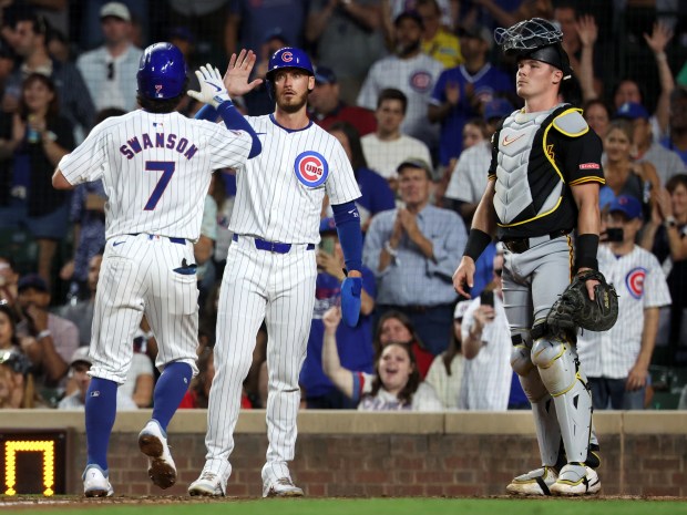 Chicago Cubs shortstop Dansby Swanson is congratulated by teammate Cody Bellinger (center) after Swanson hit a 2-run home run in the third inning of a game against the Pittsburgh Pirates at Wrigley Field in Chicago on Sept. 4, 2024. (Chris Sweda/Chicago Tribune)