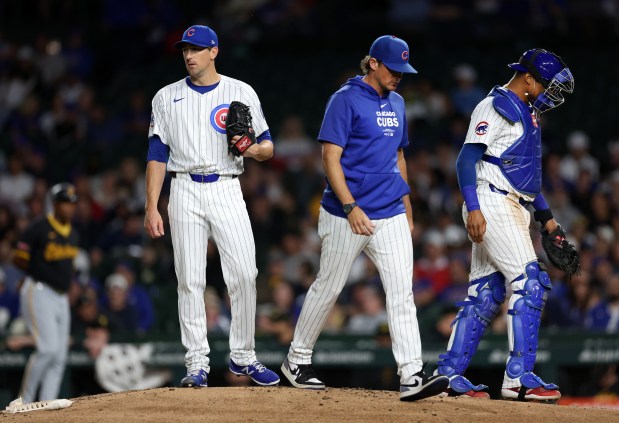 Chicago Cubs starting pitcher Kyle Hendricks stands on the mound after a meeting with pitching coach Tommy Hottrovy (center) and catcher Christian Bethancourt in the third inning of a game against the Pittsburgh Pirates at Wrigley Field in Chicago on Sept. 3, 2024. (Chris Sweda/Chicago Tribune)