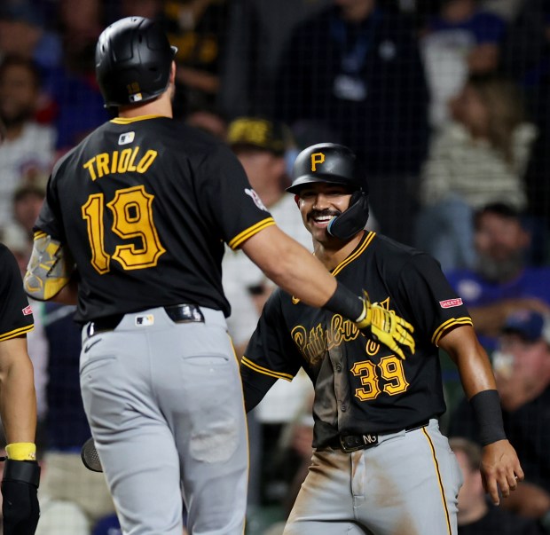 Pittsburgh Pirates second baseman Nick Gonzales (39) greets Jared Triolo at home plate after Triolo hit a 3-run home run off of Chicago Cubs relief pitcher Tyson Miller in the seventh inning of a game at Wrigley Field in Chicago on Sept. 3, 2024. (Chris Sweda/Chicago Tribune)