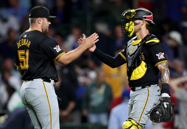 Pittsburgh Pirates relief pitcher David Bednar (51) and catcher Yasmani Grandal (6) celebrate after securing a victory by closing out the Chicago Cubs in the ninth inning of a game at Wrigley Field in Chicago on Sept. 3, 2024. (Chris Sweda/Chicago Tribune)