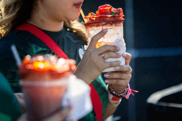 Attendees drink micheladas de modelo at El Grito Chicago, a two-day festival in celebration of Mexican Independence Day, at Grant Park's Butler Field in Chicago on Sept. 14, 2024. (Tess Crowley/Chicago Tribune)