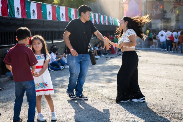 Sebastian Aguilar, from Chicago, left, and girlfriend Citlali Hernandez, from Indiana, right, dance at El Grito Chicago, a two-day festival in celebration of Mexican Independence Day, at Grant Park's Butler Field in Chicago on Sept. 14, 2024. (Tess Crowley/Chicago Tribune)