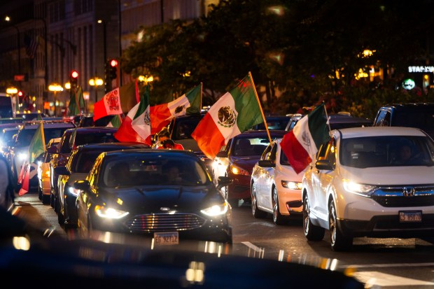 People ride down Michigan Avenue in celebration of Mexican Independence Day in Chicago on Sept. 14, 2024. (Tess Crowley/Chicago Tribune)