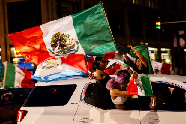 People ride down Michigan Avenue in celebration of Mexican Independence Day in Chicago on Sept. 14, 2024. (Tess Crowley/Chicago Tribune)