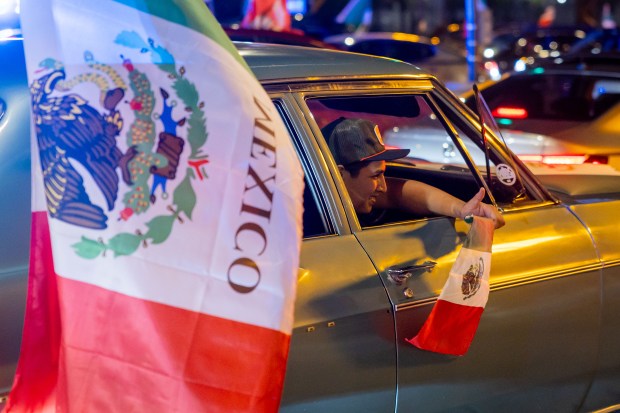 People ride down Michigan Avenue in celebration of Mexican Independence Day in Chicago on Sept. 14, 2024. (Tess Crowley/Chicago Tribune)