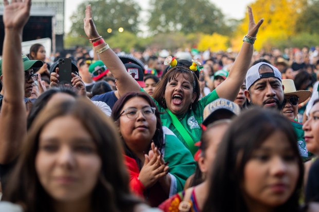 People cheer as they listen to Sonora Santanera's performance on the main stage at El Grito Chicago, a two-day festival in celebration of Mexican Independence Day, at Grant Park's Butler Field in Chicago on Sept. 14, 2024. (Tess Crowley/Chicago Tribune)