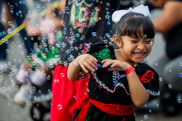 Sophia Ramirez, 4, tries to dodge bubbles at El Grito Chicago, a two-day festival in celebration of Mexican Independence Day, at Grant Park's Butler Field in Chicago on Sept. 14, 2024. (Tess Crowley/Chicago Tribune)