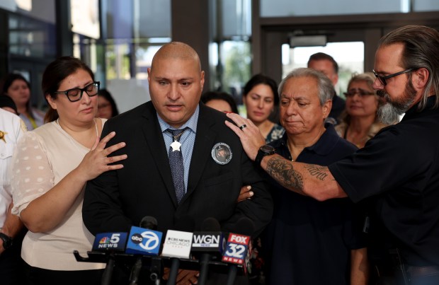 Former Chicago police Officer Carlos Yanez Jr. is consoled by loved ones, including his father, Carlos Yanez Sr., second from right, while speaking after the sentencing of Emonte Morgan in the killing of Yanez Jr.'s partner, Officer Ella French. The sentencing took place at the Leighton Criminal Court Building in Chicago on Wednesday, Sept. 11, 2024. French was killed in August 2021. (Chris Sweda/Chicago Tribune)