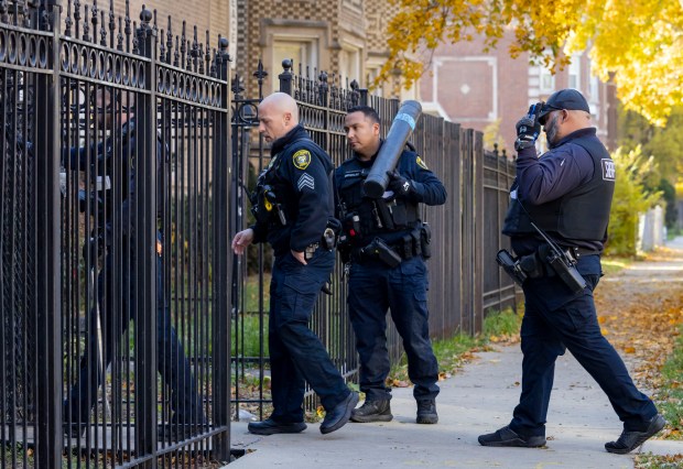 Members of the Cook County sheriff's office eviction unit enter a multi-unit building in Chatham to perform a court-ordered eviction on Nov. 14, 2023. (Brian Cassella/Chicago Tribune)