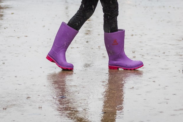 Jacquee Djavaheri Forkash, 9, from San Francisco, walks on Wacker Drive during heavy rain in Chicago on Sept. 24, 2024. (Tess Crowley/Chicago Tribune)