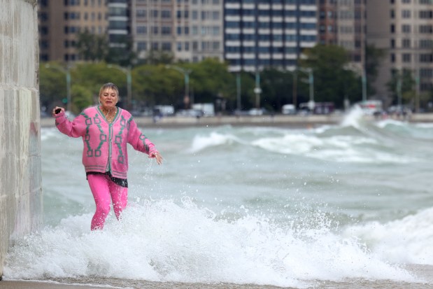 A person gets hits by the crashing waves from Lake Michigan on the bike and pedestrian path at 1100 N. Lake Shore Drive on Friday, Sept. 27, 2024. Hurricane Helene, the powerful storm that crashed into Florida late Thursday as a Category 4 hurricane, delivered strong winds to the Chicago area. Rain from the storm is also forecast for the weekend. (Antonio Perez/Chicago Tribune)