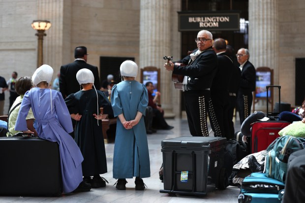 Members of five families from Fremont, Michigan, listen as the Mariachi band Los Palmeros perform in the Great Hall of Chicago's Union Station on Wednesday, Sept. 18, 2024. The band was on hand to entertain during an event honoring the legacy of Latino railroad workers at Amtrak and in Illinois. The Michigan families were traveling through Chicago en route to Montana. (Chris Sweda/Chicago Tribune)