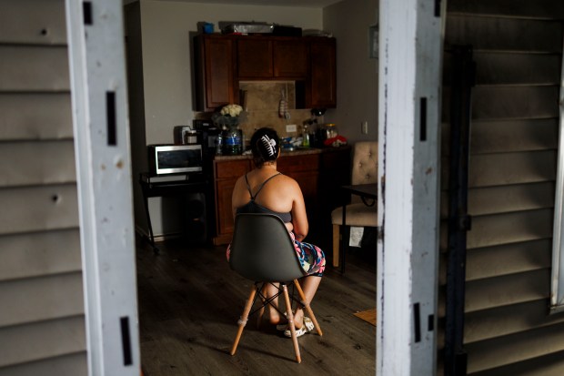 An abuse victim, whose name is being withheld, poses for a portrait at her home in the Austin neighborhood on Aug. 15, 2024, in Chicago. (Armando L. Sanchez/Chicago Tribune)