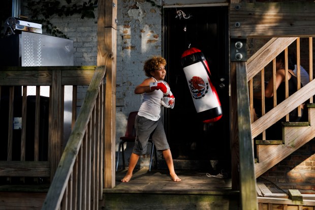 Engerberth Morales, 9, plays with a punching bag while posing for a portrait in his backyard at home in the Englewood neighborhood on Aug. 27, 2024, in Chicago. Last year Engerberth's mother Angelica Beltran knew the transition from Venezuela hadn't been easy for Engerberth, so she didn't push him to go to school. (Armando L. Sanchez/Chicago Tribune)