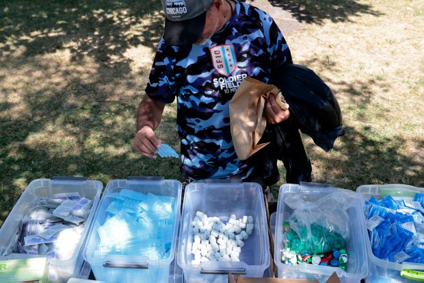 Joe Gonzalez fills a bag with supplies used by addicts, given out by the Puerto Rico Project at Humboldt Park in Chicago on Sept. 9, 2024. (Antonio Perez/Chicago Tribune)