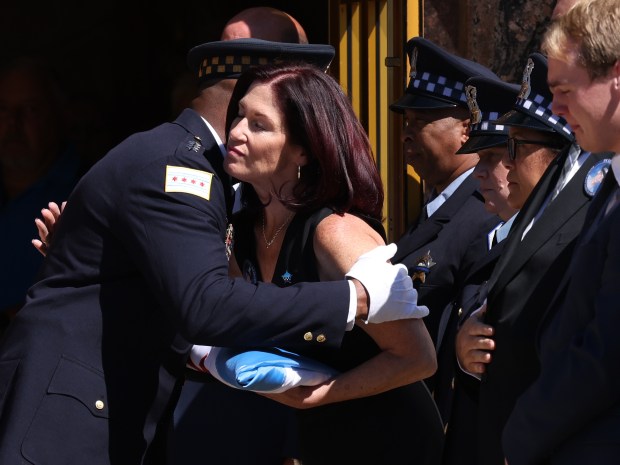 Chicago Police Superintendent Larry Snelling presents the Chicago flag to Beth Carter, sister of Officer James Crowley, following his funeral at St. Christina Church on Sept. 4, 2024. (Antonio Perez/Chicago Tribune)