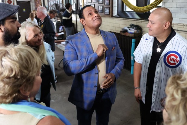 Former Chicago Cubs star player Sammy Sosa speaks with police Officer Carlos Yanez Jr., who was critically wounded in the Aug. 2021 shooting that killed his partner Ella French, and others at the Chicago Fire Department firehouse Engine 98/Ambulance 11, before presenting a $10,000 donation to charities , EMWQ Retirees, Widows' & Children's Assistance Fund and Light the Line, that supports Chicago Police Department. (Antonio Perez/Chicago Tribune)