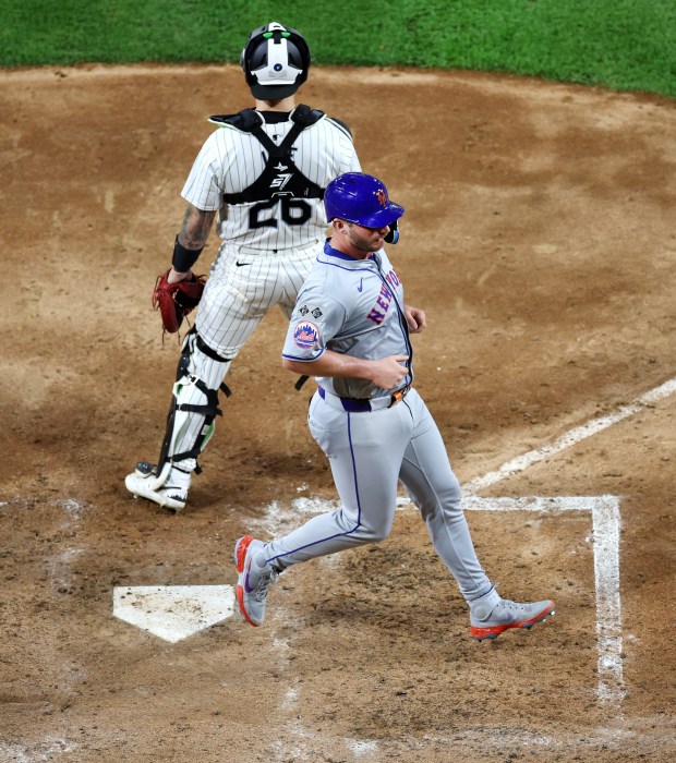 New York Mets first baseman Pete Alonso (20) crosses home plate in front of Chicago White Sox catcher Korey Lee (26) as Alonso scored a run on a single by teammate Starling Marte in the sixth inning of a game at Guaranteed Rate Field in Chicago on Aug. 31, 2024. (Chris Sweda/Chicago Tribune)