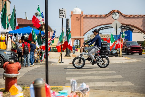 A person bikes down 26th Street in the Little Village neighborhood of Chicago on Sept. 10, 2024. (Tess Crowley/Chicago Tribune)