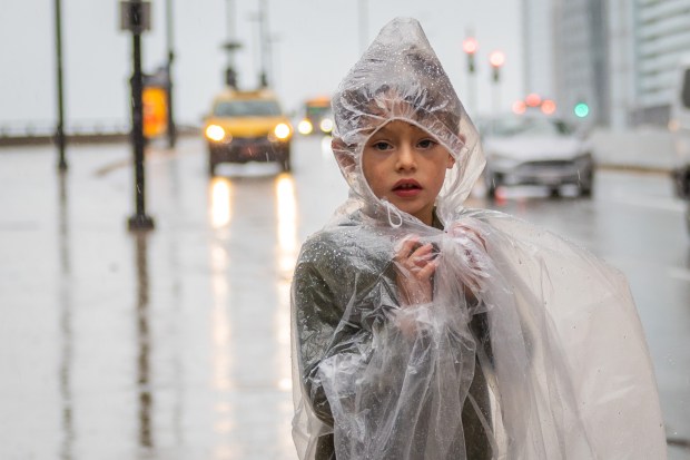 Saul Djavaheri Forkash, 5, from San Francisco, looks over Wacker Drive during a downtown Chicago downpour, Sept. 24, 2024. (Tess Crowley/Chicago Tribune)